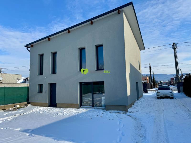 A family house on Gyňovská Street in Čaňa during winter with a white facade and a snowy road.