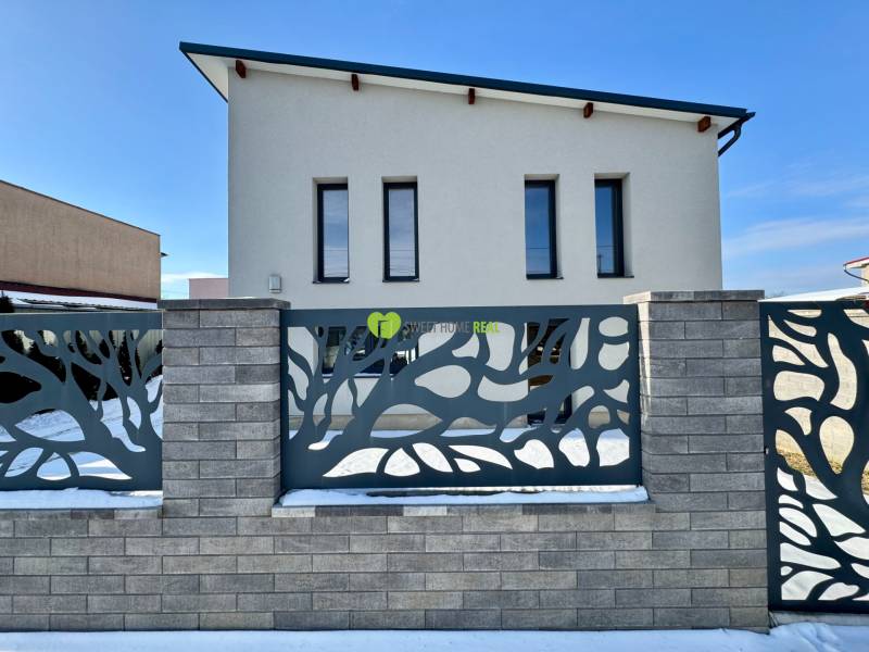 A family house on Gyňovská Street in Čaňa with a modern fence and a snow-covered garden.