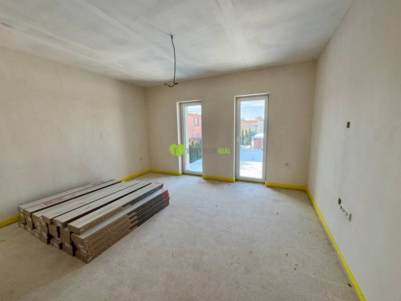 A spacious room in a family house with packages of laminate flooring, ready for installation.