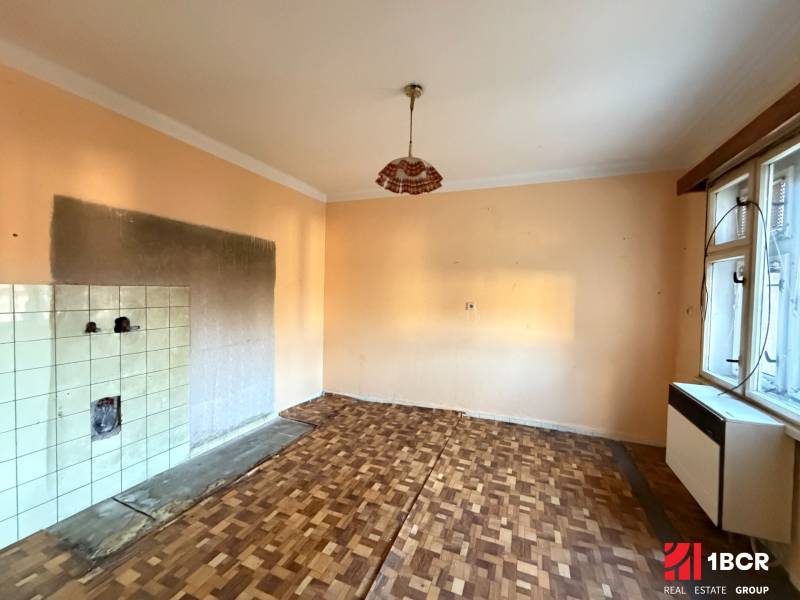 A room with a window, a floor with wood decor, and ceramic tiles, family house.