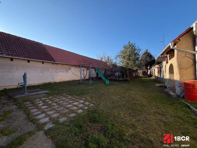 The garden of a family house on Bratislavská Street in Svätý Jur, with a playground and a garden pump.