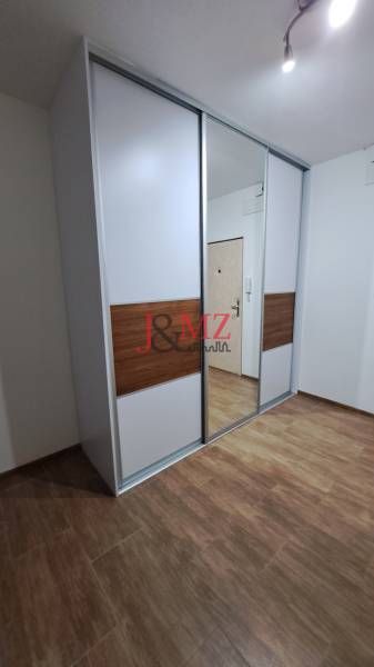 Built-in wardrobe with sliding doors and a mirror in a 2-room apartment.