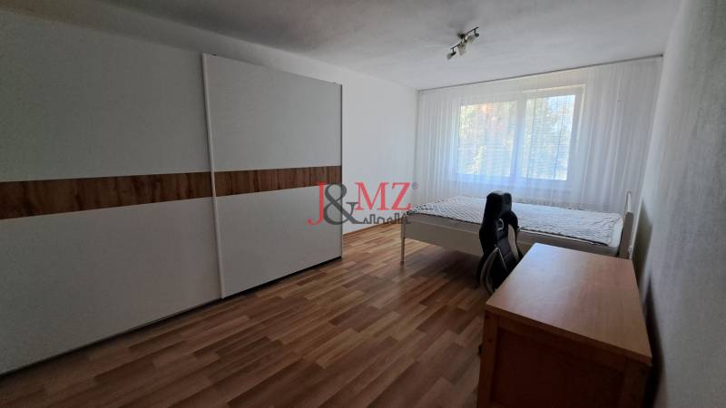 A bright room in a 2-room apartment with a wardrobe, bed, and desk.