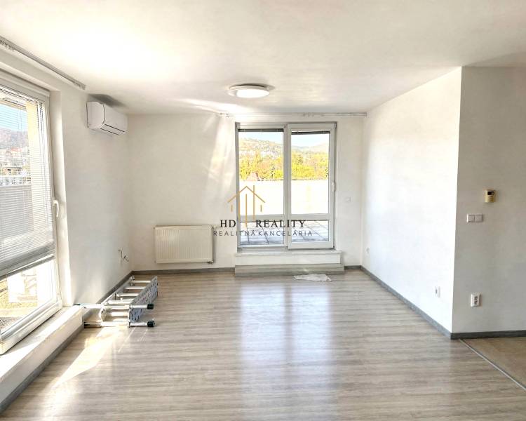 Spacious bright living area with wood-effect flooring in a 2-room apartment.