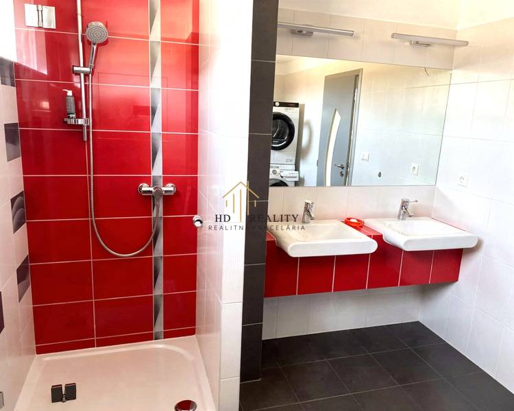 A bathroom with red and white tiles in a 2-room apartment.