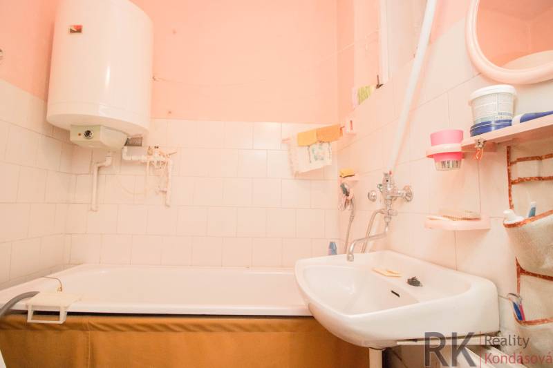 Bathroom with a bathtub, sink, and water heater in a family house.
