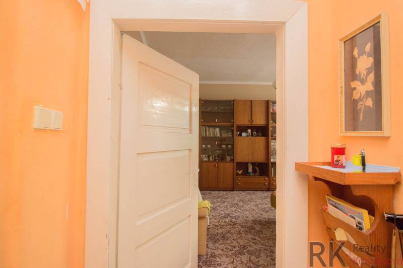 A family house with orange walls, wall decoration, and a niche with storage space.