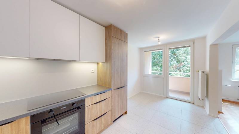 A kitchen with a built-in oven and wooden decor doors in a 4-room apartment.