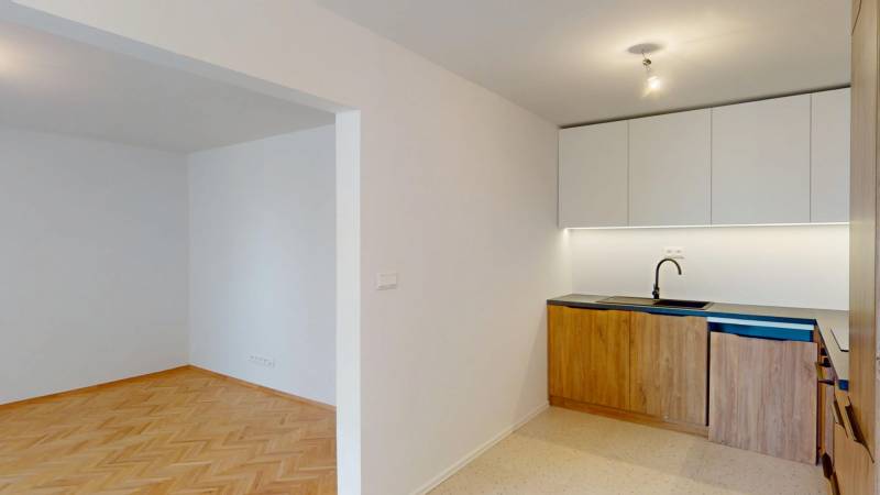 The kitchen in a 4-room apartment with a built-in unit and flooring with a wood decor.