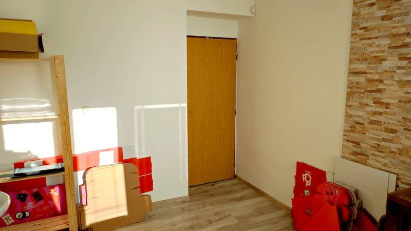 Offices with wood-patterned flooring, light-colored walls, and doors with a paneling background.