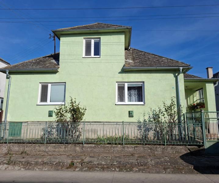 A family house in Malé Leváre with a light green facade and a steep roof.