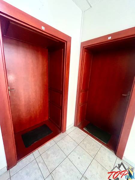 Wooden entrance doors with numbers and light-colored tiles in the offices.