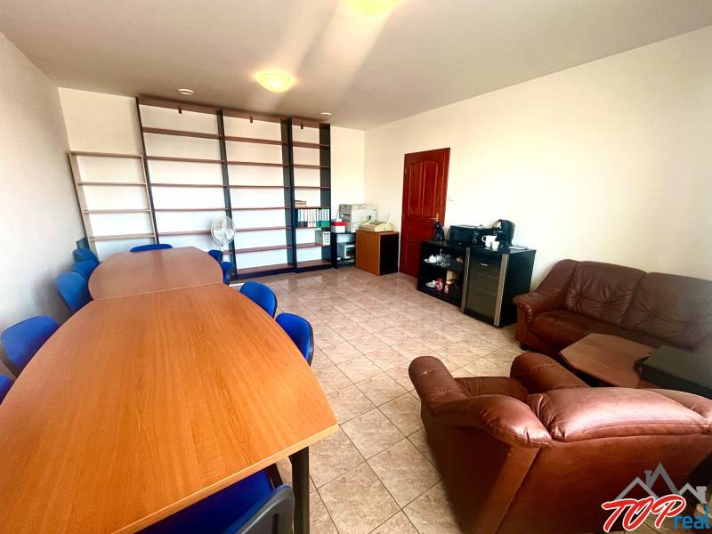 Offices with wood-patterned flooring, a conference table, and a bookshelf.