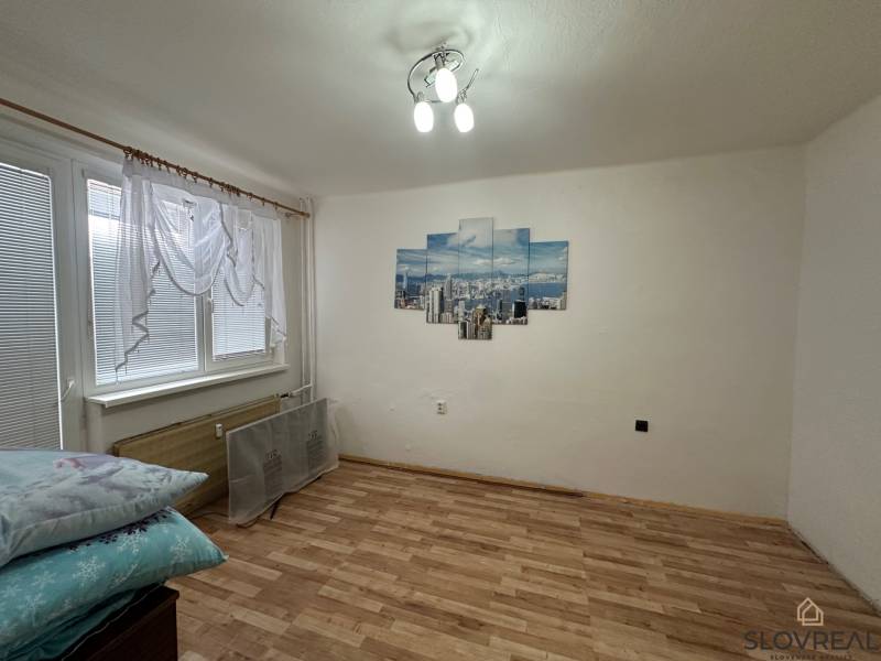 A room in a 3-room apartment with a decorative painting and a floor with a wooden decor.
