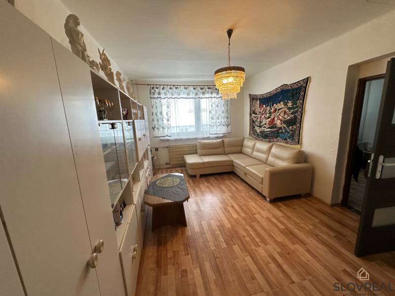 Living room with a sofa and furniture in a 3-room apartment with a wooden decor floor.