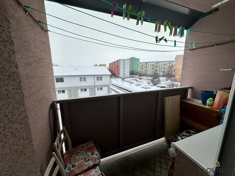 A balcony in a 3-room apartment in Levice, with a view of a snowy street.