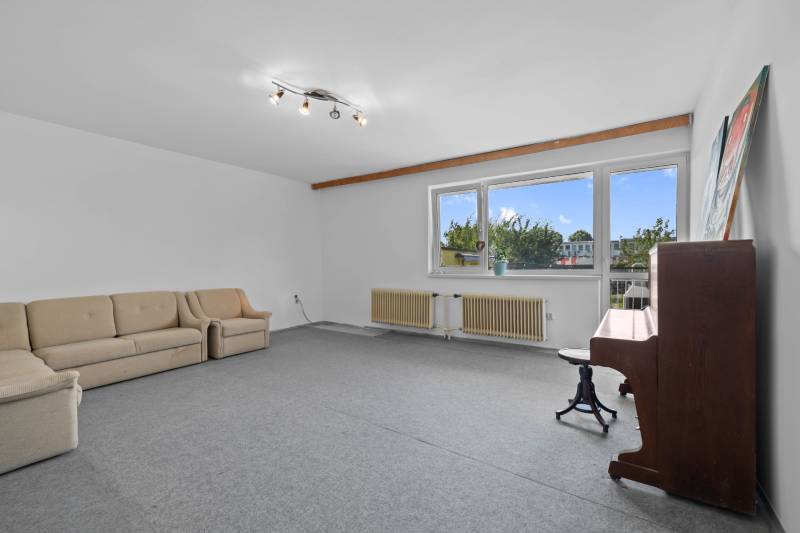 Living room with a sofa and a piano in a family house.