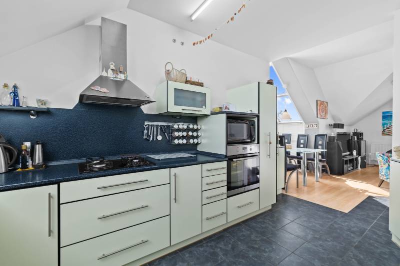 A kitchen in a family house with an oven, stove, and dining area.