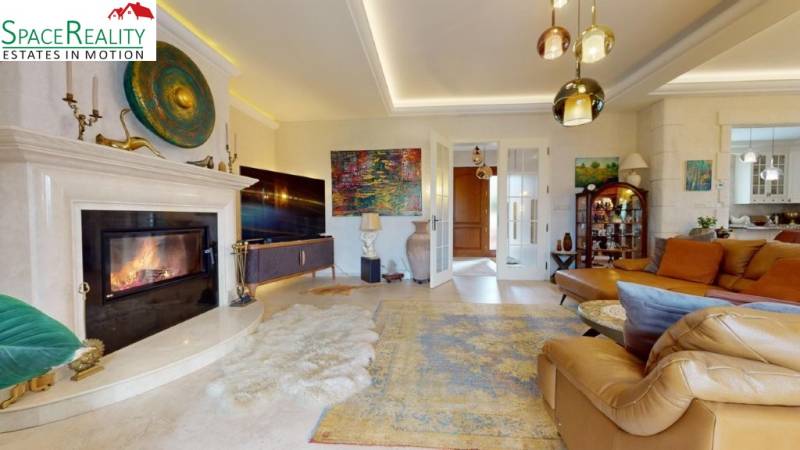 Living room of a family house with a fireplace, comfortable sofa, and decorative artworks.