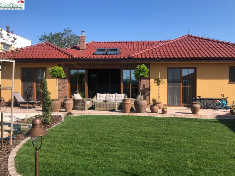 A family house in Bratislava - Jarovce with a terrace, garden, and red roof.