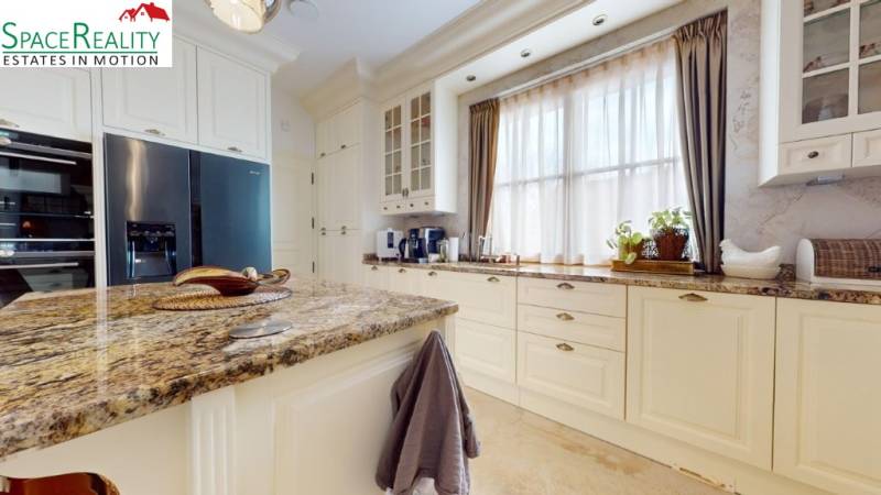A kitchen in a family house with a granite countertop and large windows.