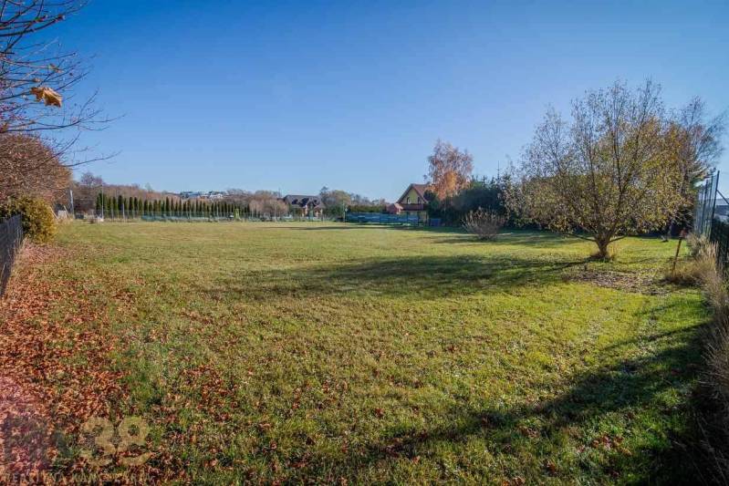 Land - living in Veľká Lomnica, lawn surrounded by trees and a fence.