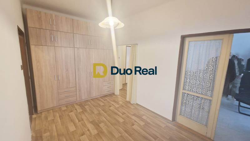 Interior of a 3-room apartment with a wooden decor floor and a built-in wardrobe.