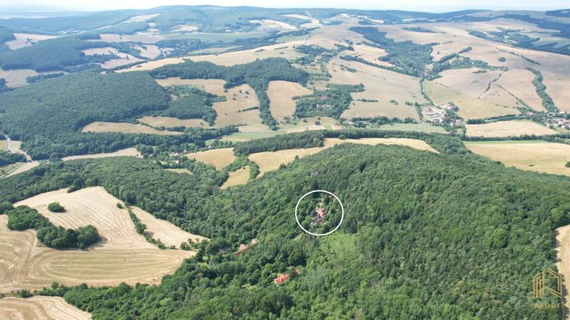 Aerial view of a family house in the village of Vrbovce amidst picturesque nature and fields.