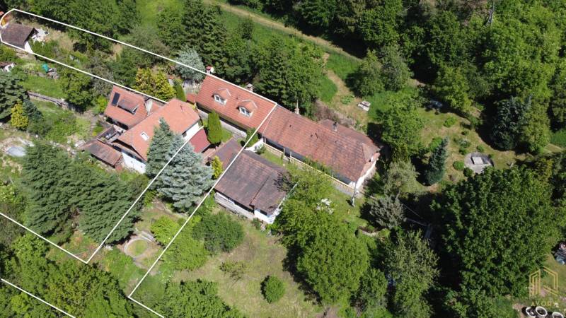 An aerial view of a family house in Vrbovce surrounded by greenery and trees.