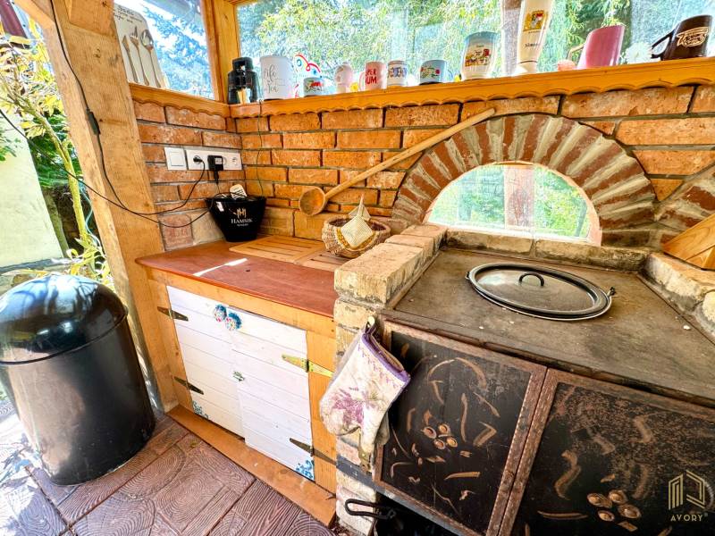 Rustic kitchen in a family house with brick decor and window sills full of mugs.
