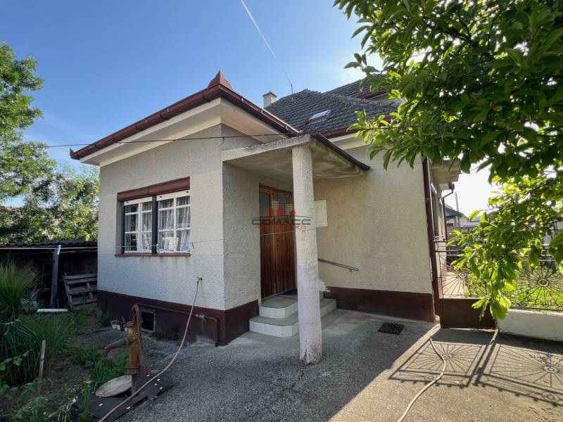 A family house in Drahovce on Drahovce Street with a garden and a narrow entrance gate.