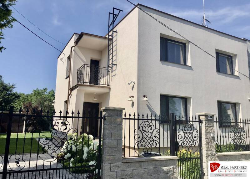 Two-story house with a balcony in Most pri Bratislave, brick fence, garden.