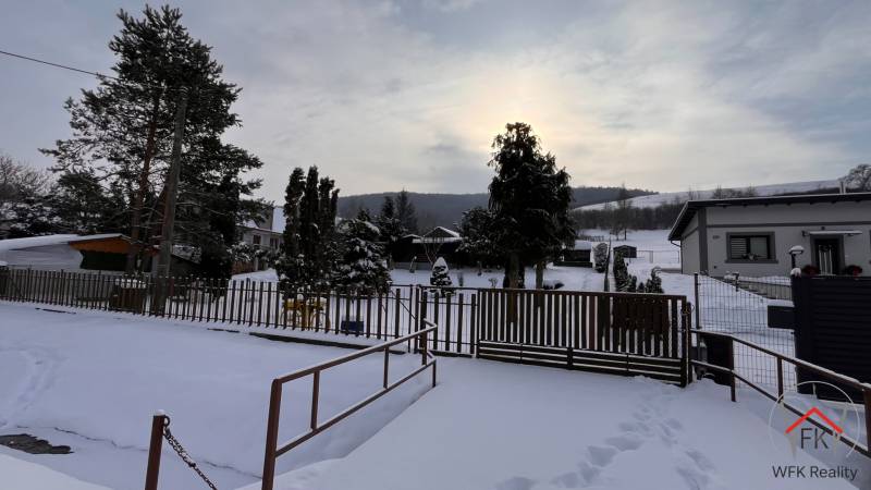 Winter scenery on the grounds - living in Jasenovce on Jesenovce street with a view of snow-covered hills.