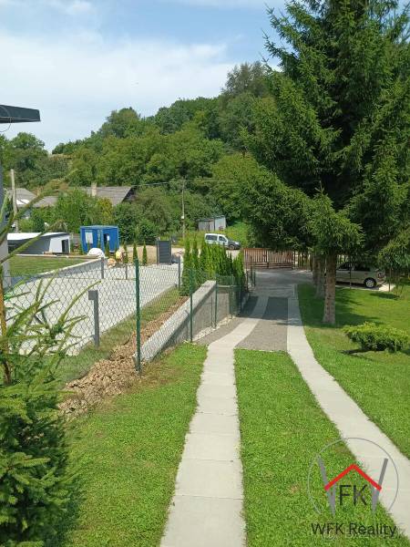 The sidewalk runs alongside the green lawn in Jasenovce on Jesenovce Street, suitable for residential plots.