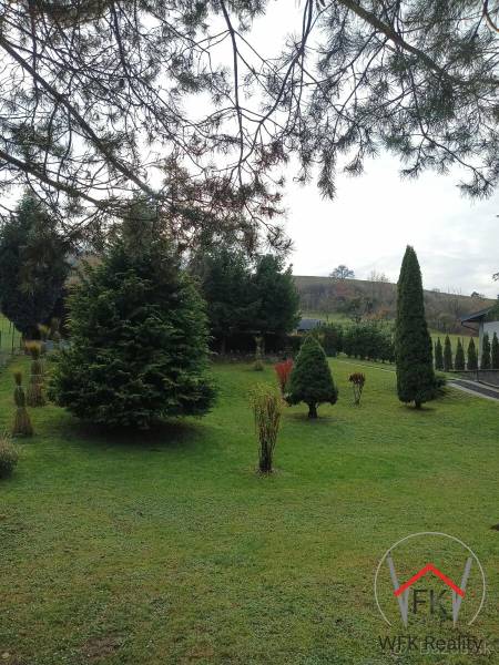 A garden with coniferous trees in Jasenovce on Jesenovce Street, suitable for residential plots.