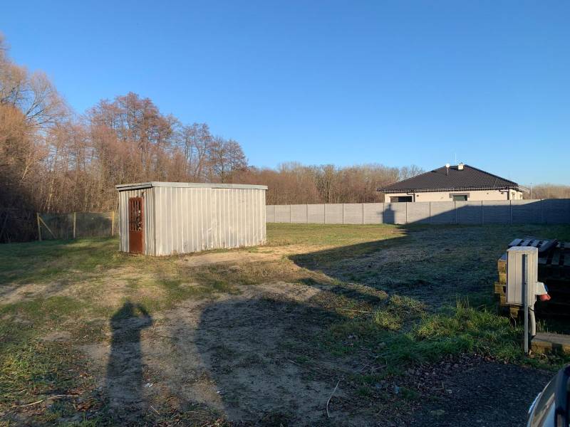 Plots - housing in Malé Leváre with a metal warehouse and grassy area.