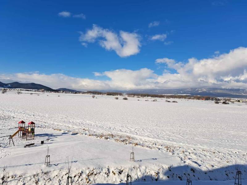 A snowy playground with a view of the snowy landscape and the High Tatras in Poprad.