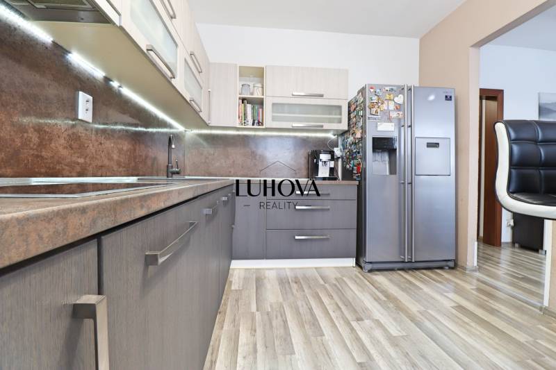 A kitchen in a 3-room apartment with a wooden decor countertop and flooring.