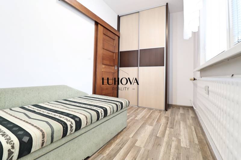 Interior of a 3-room apartment with a sofa, wardrobe, and floor with a wooden decor.