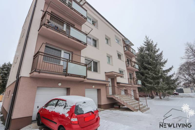 Apartment building with a red car on the snowy St. Stephen's Street in Piešťany.