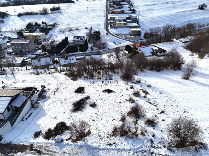 Snow-covered residential plots in Horná Mičiná with views of the surrounding houses and landscape.