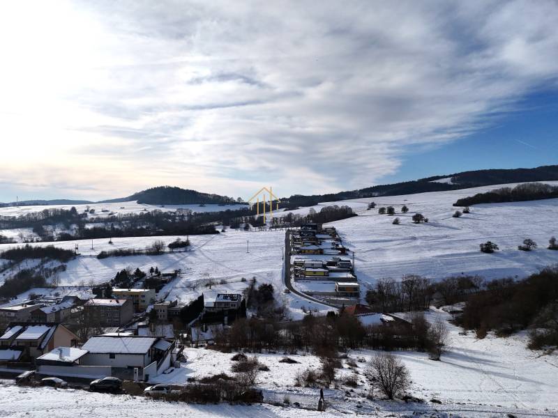 Snowy landscape with a view of plots in Horná Mičiná, designated for residential use.