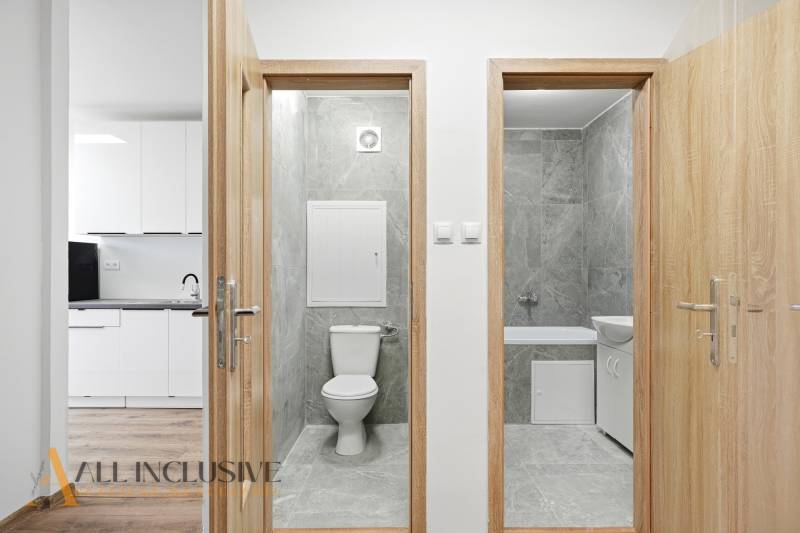 Bathroom and toilet in a 3-room apartment with a kitchen and a wooden decor floor.