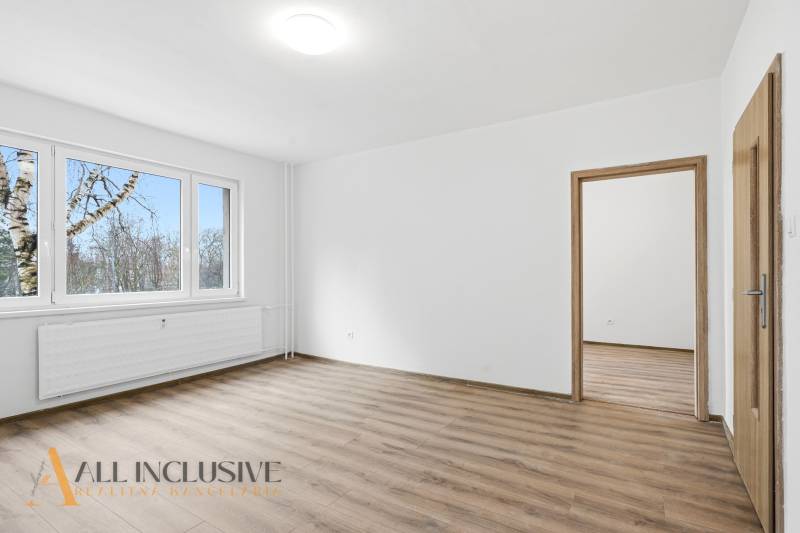 A bright interior with wood-patterned flooring in a 3-room apartment.