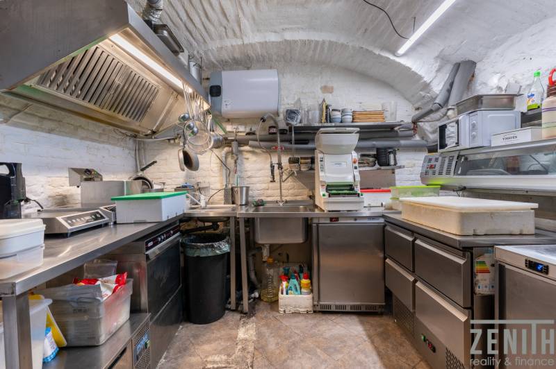 Professional kitchen with stainless steel surfaces and equipment in catering spaces.