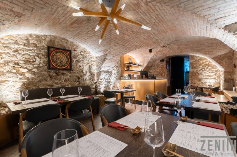 Interior of a gastro space with vaulted stone walls and modern lighting.