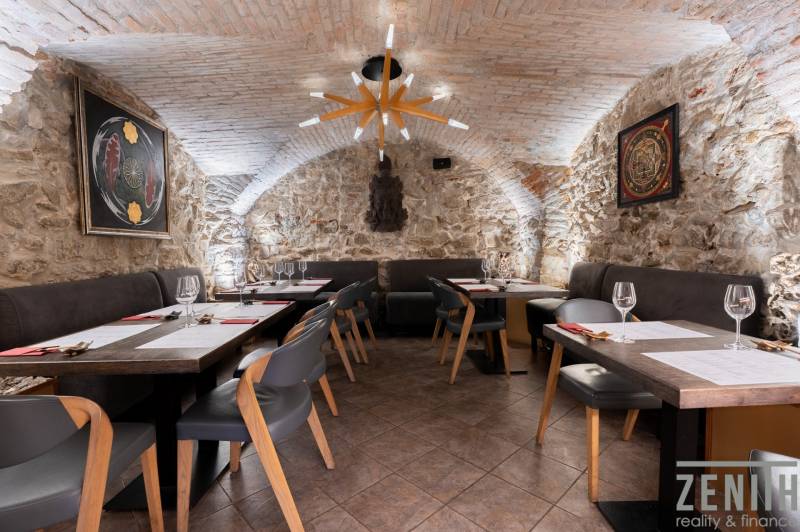 Stone walls and arched ceiling in the interior of the Gastro spaces with elegant furniture.