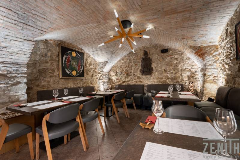 Vaulted ceiling and stone walls with paintings in the dining area.