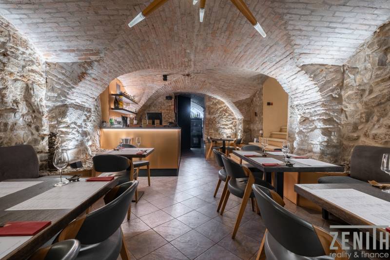 Historical gastro spaces with stone walls and brick vaulting, flooring with a wooden decor.