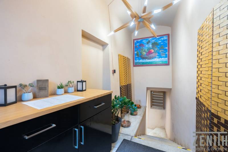 Interior of gastro spaces with decorative lighting, wooden decor, and a colorful painting.